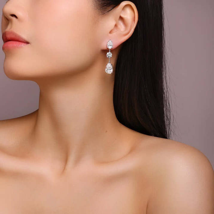 Elegant woman wearing Moissanite Earrings made of 925 sterling silver, showcasing their sparkling brilliance.