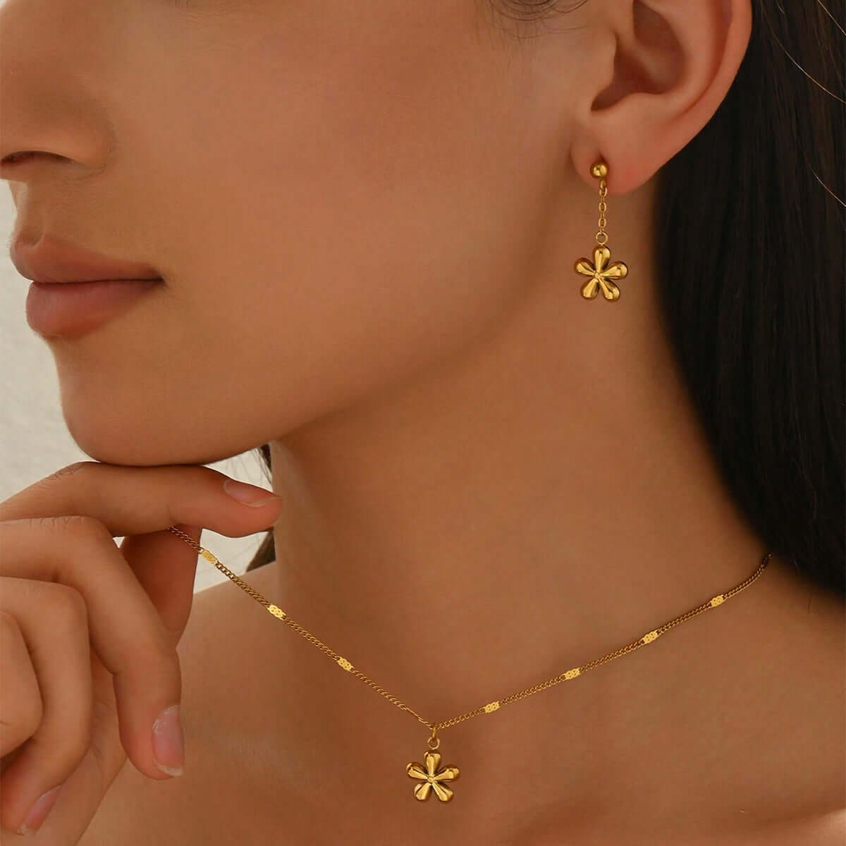Gold Flower Necklace Set worn by a woman, showcasing 18K gold plated earrings and necklace with floral charms.